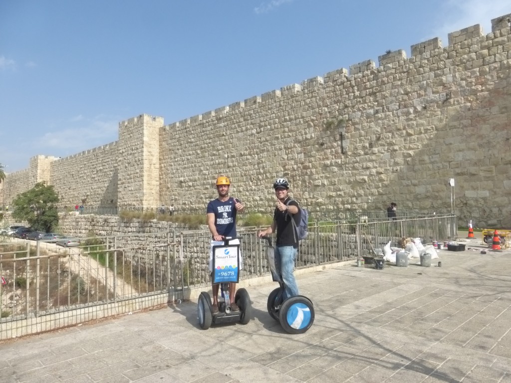 O guia e sócio da Smart Tour Israel, Amichai Warter (à dir.), e turista junto à muralha da Cidade Velha de Jerusalém