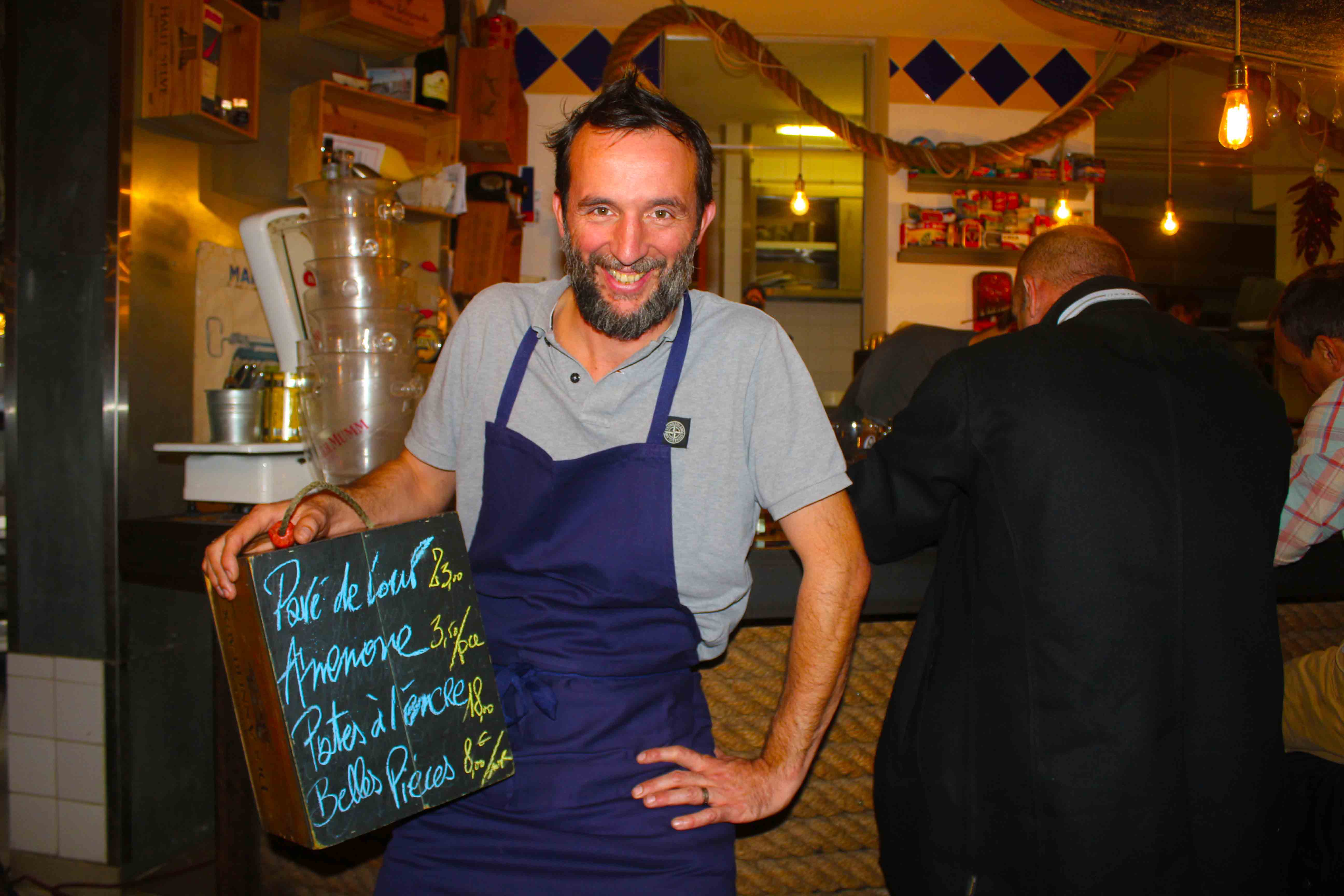 O chef Fabien Ruei exibe o cardápio do dia numa pquqena louza escrita à mão
