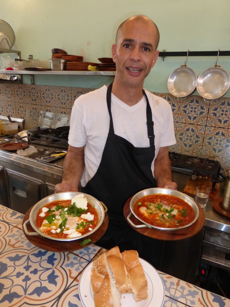 O cozinheiro Tzvika exibe as shakshukas que ele prepara no restaurante Shukshuka, em Tel Aviv