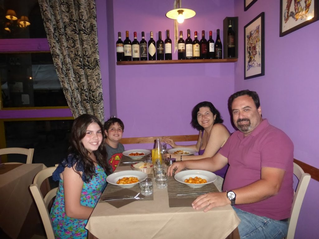 Eu com minha esposa, Mirella, e os meus enteados, Henrique e Giulia, antes de comer as massas