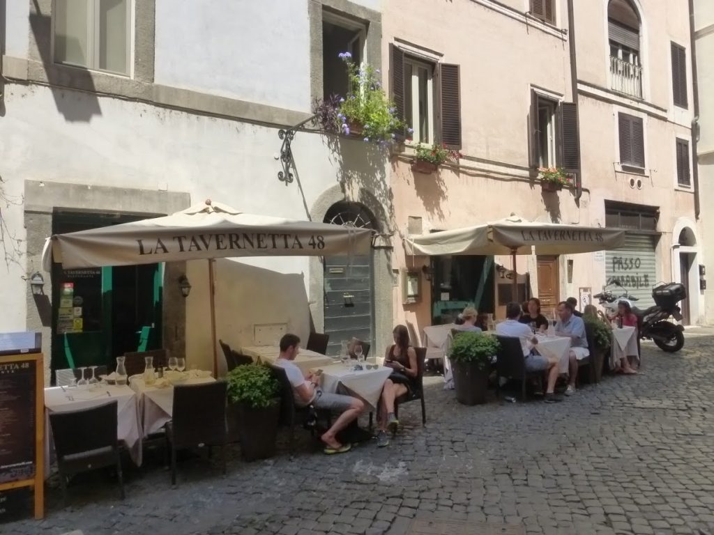 Entrada e mesas do restaurante, que fica "escondido" em rua perto da Piazza Navona
