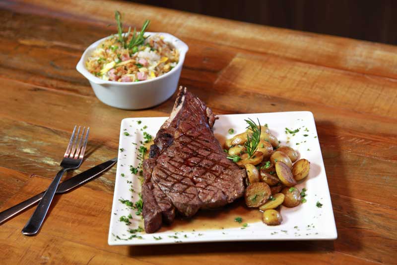 O Cowboy Steak Jack Daniel’s, corte dianteiro com gordura marmorizada, acompanhado de arroz biro-biro e batatas bolinha (fotos divulgação Paulo Cunha/Outra Visão)