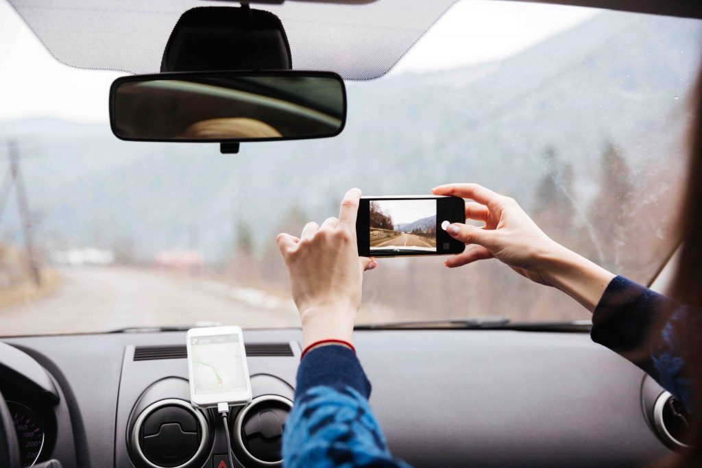 woman-hands-driving-and-taking-photos-with-mobil
