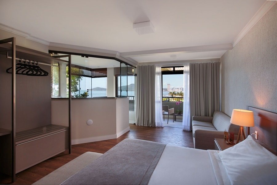 Suíte luxuosa do resort com cama, sofá e varanda Infinity Blue